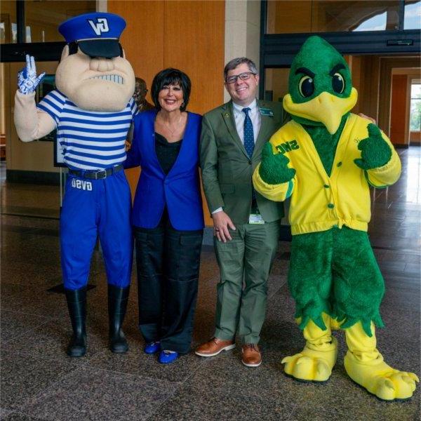 Louie the Laker at right and the SMC road runner mascot at left stand next to SMC president and President Mantella